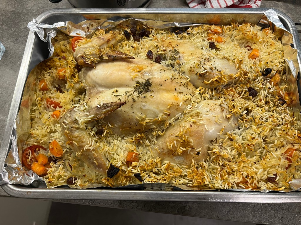 Finished dish, roast chicken in colourful rice. 