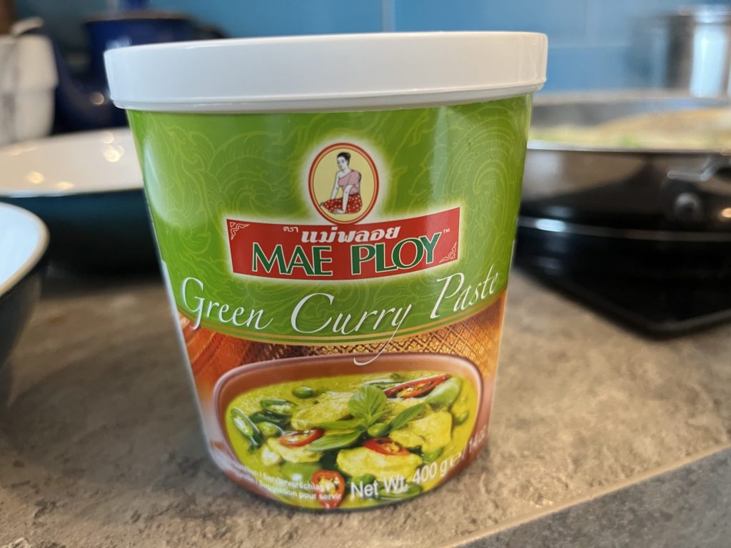 Plastic jar of Mae Ploy brand green curry paste.