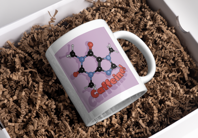 White mug with a cartoon caffeine molecule on a pale purple background, and the word 'Caffeine!' underneath.