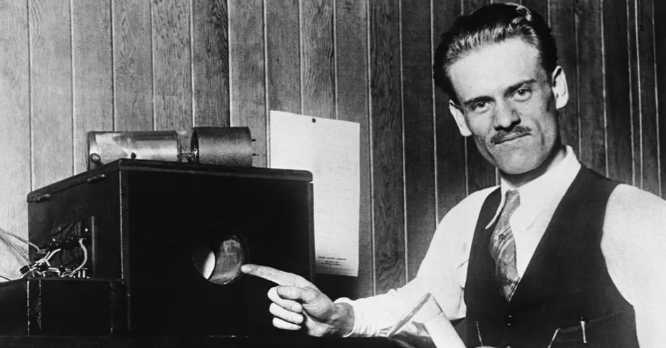 Black and white photo of Philo Farnsworth and one of his very early televisions. The screen is about 10 cm in diameter.